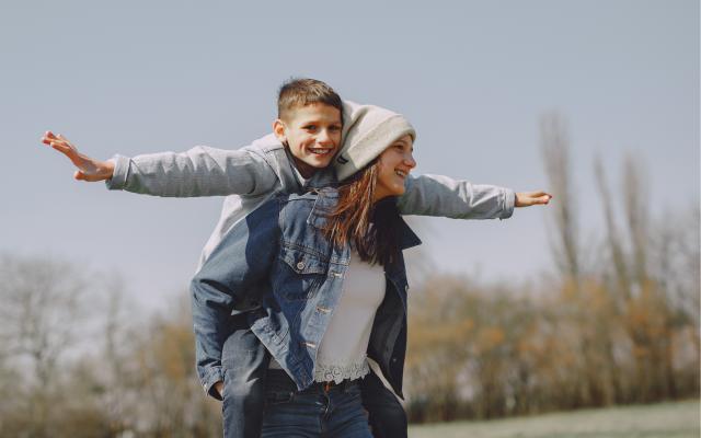 Stödperson med barn på ryggen